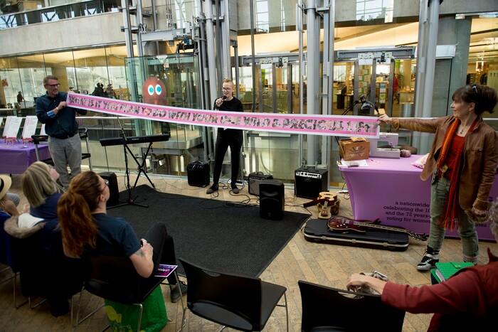(Jeremy Harmon  |  The Salt Lake Tribune) Artist Marilyn Artus, center, talks about the Her Flag project as Jann Haworth and Andy Artus display a portion of the flag during an event at the downtown library in Salt Lake City on Wednesday, Nov. 6, 2019.