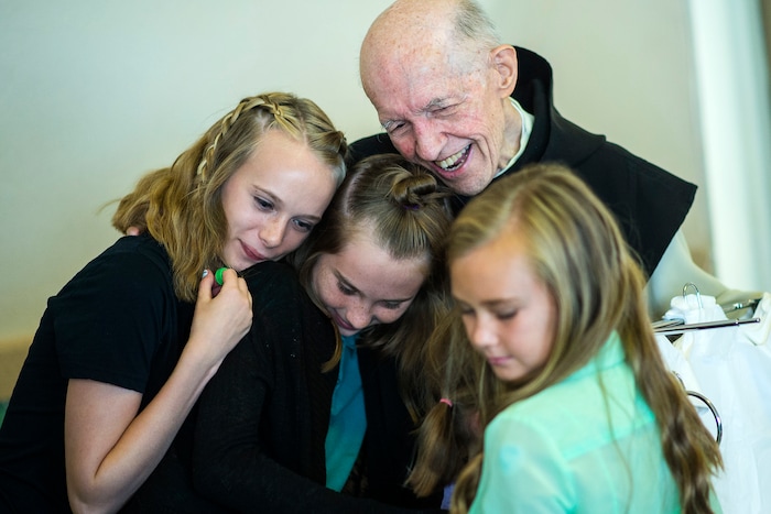 (Chris Detrick  |  The Salt Lake Tribune)  "Father Patrick" Boyle hugs Emma Vore, 14, Erin Vore, 12, and Ally Vore, 10, in the bookstore and gift shop at the Abbey of Our Lady of the Holy Trinity in Huntsville on Wednesday, Aug. 23, 2017.