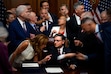 (Julia Demaree Nikhinson | AP) Republican members of Congress reach to shake hands with Speaker of the House Mike Johnson, R-La., center bottom, after Johnson signed President Donald Trump's signature bill of tax breaks and spending cuts, Thursday, July 3, 2025, at the Capitol in Washington.